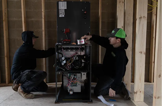Two Monster Air technicians installing a new furnace and air handler
